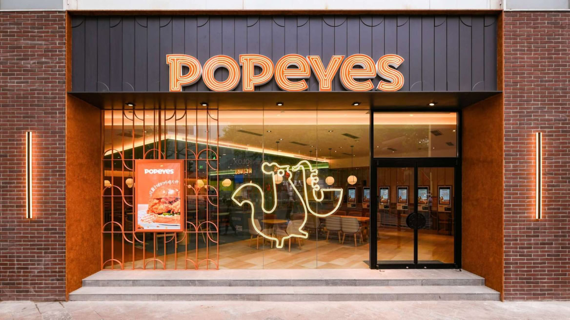 entrée moderne du restaurant popeyes illuminée