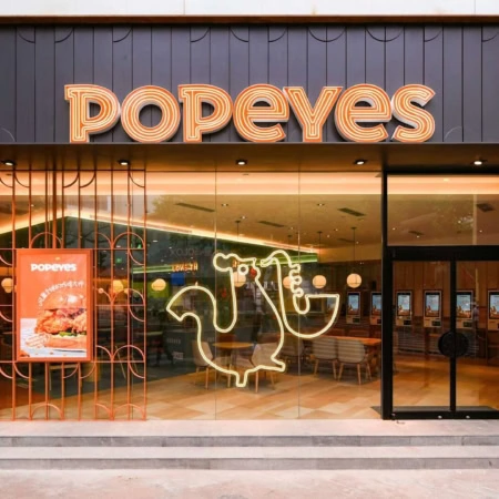entrée moderne du restaurant popeyes illuminée