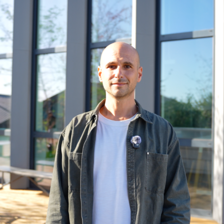 portrait d’un homme devant un bâtiment moderne