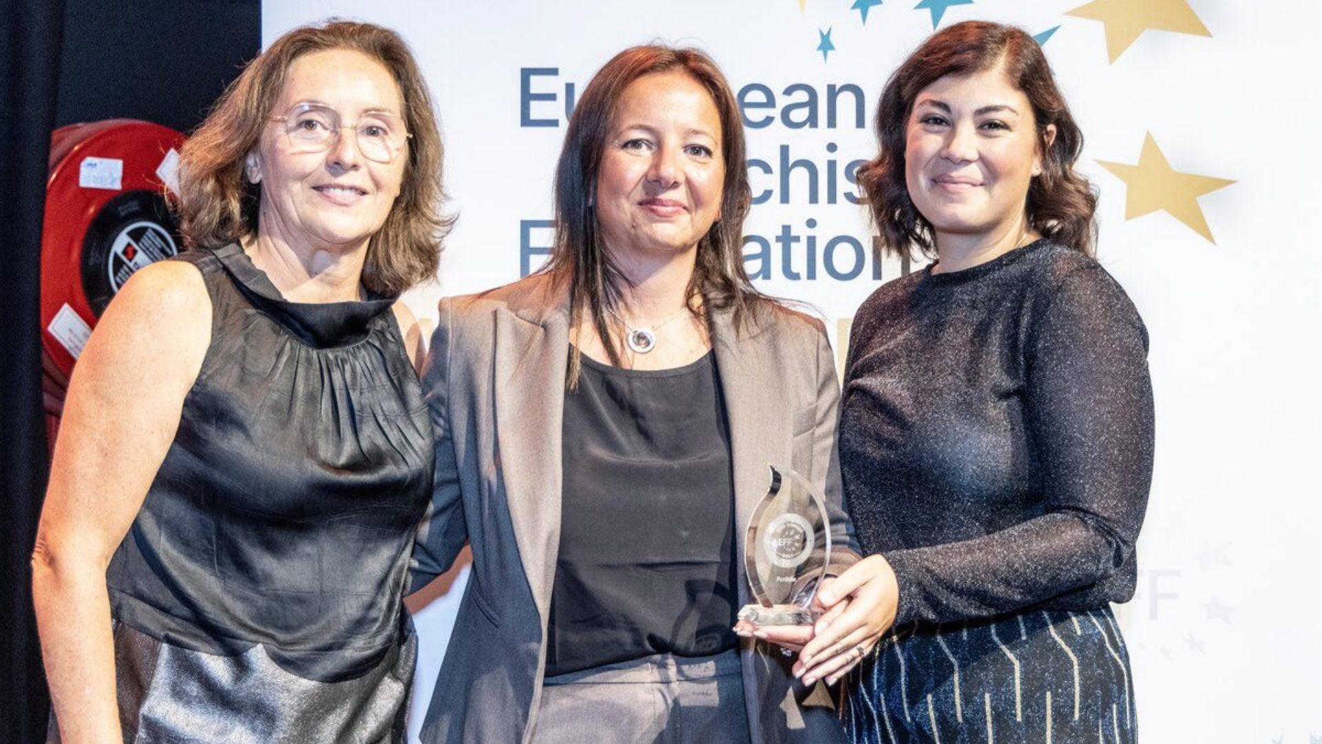 remise de prix : trois femmes et trophée