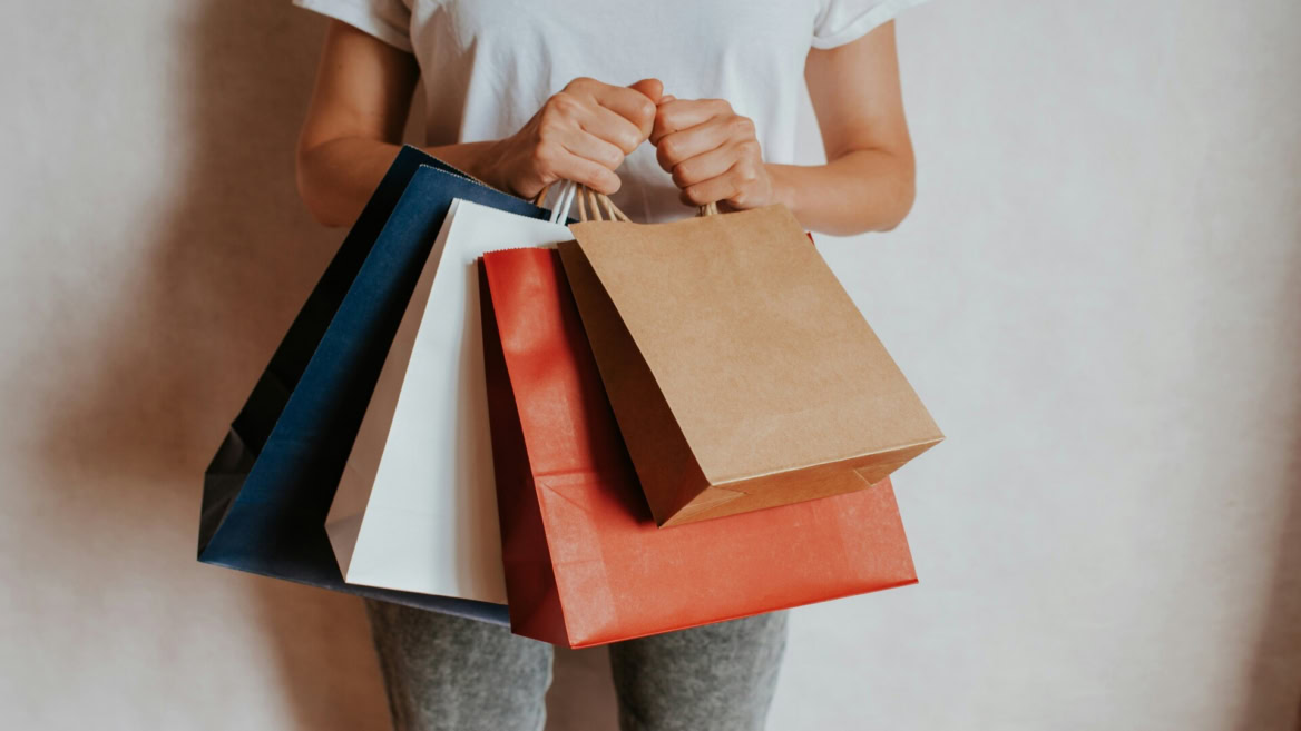 person carrying colourful shopping bags