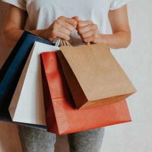 person carrying colourful shopping bags
