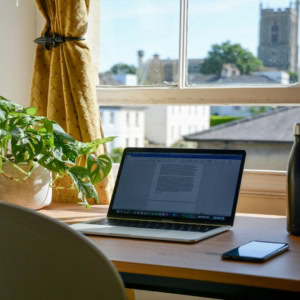 sunlit home office with laptop and window view