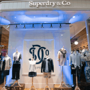 vitrina superdry en centro comercial con maniquíes y luces azules