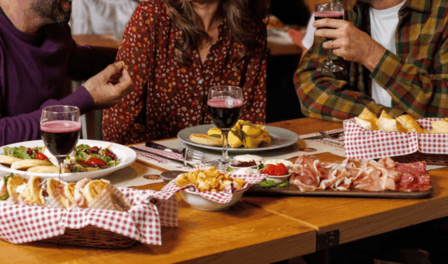 tavolata conviviale con vino e salumi