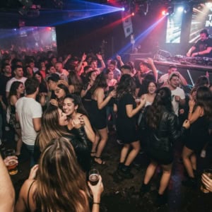 multitud en club techno con dj y luces led