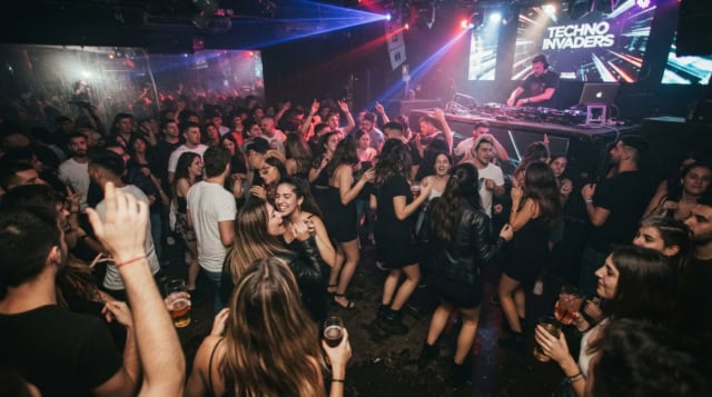 multitud en club techno con dj y luces led