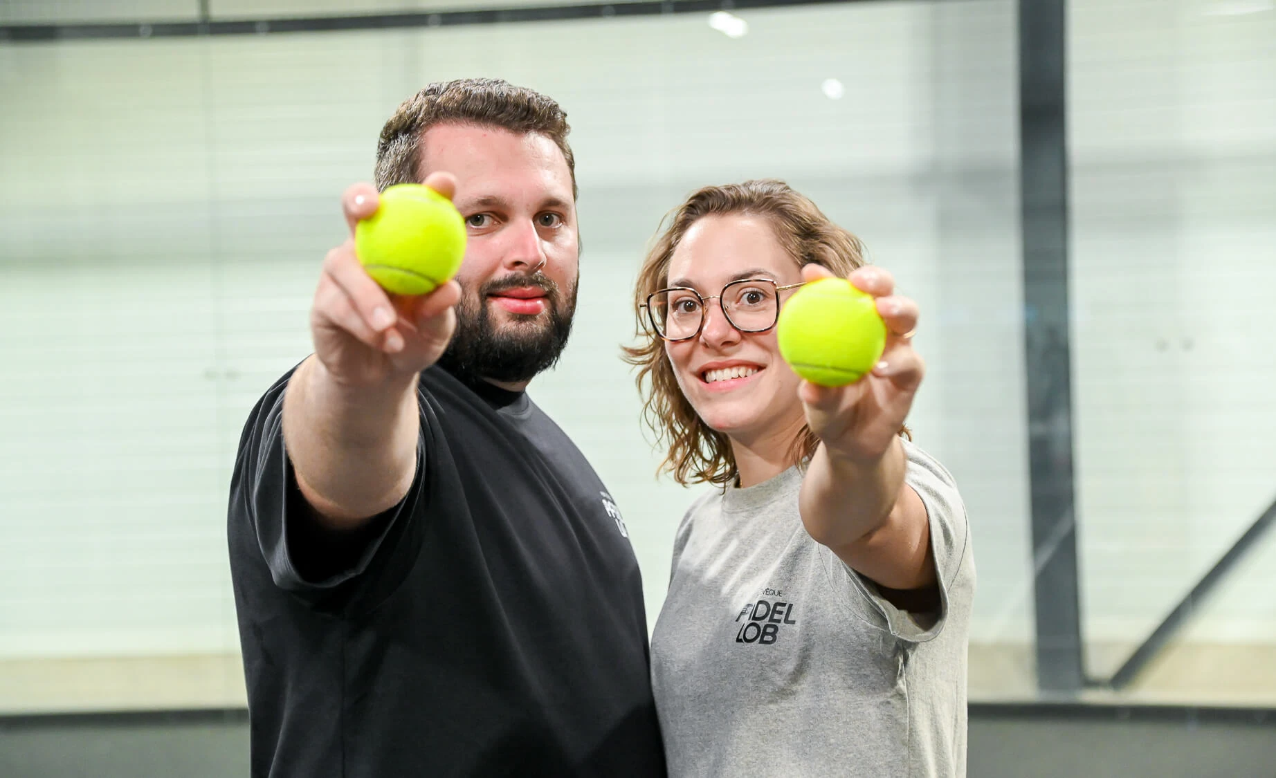 portrait couple tennis, sourires et balles jaunes