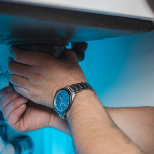 under sink plumbing repair with hands tightening fitting
