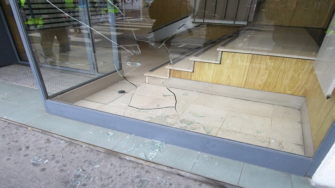 vitrine de magasin brisée, éclats de verre au sol