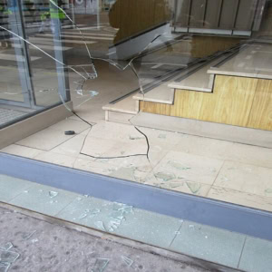 vitrine de magasin brisée, éclats de verre au sol