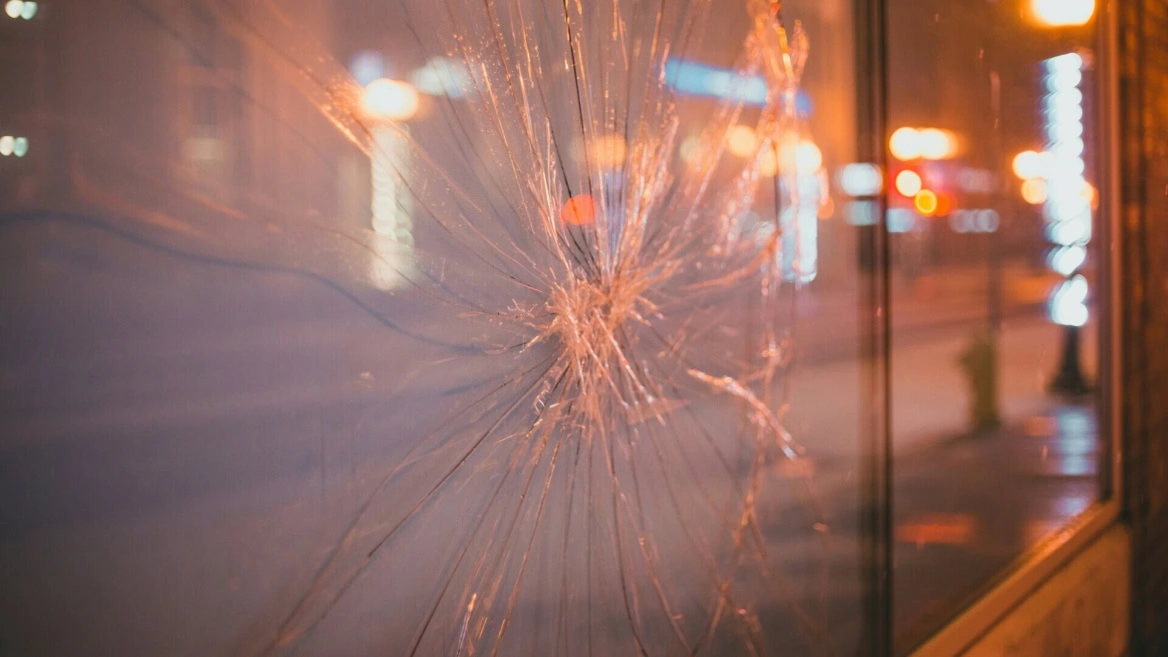 vitre fêlée, reflets de ville la nuit
