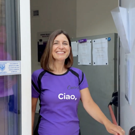 donna sorridente sulla soglia di un negozio