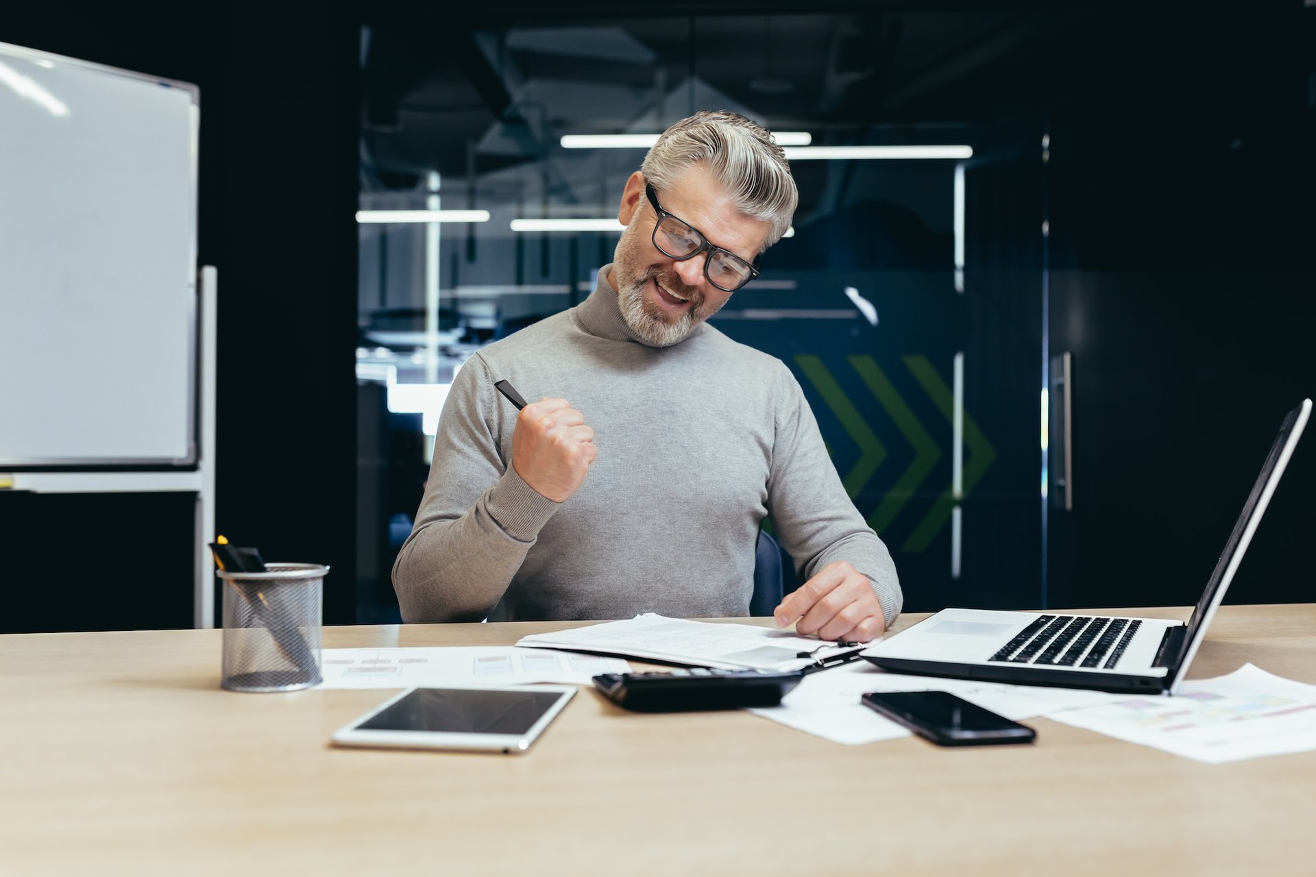 a senior business man in the office and signing a successful contract making a profitable deal